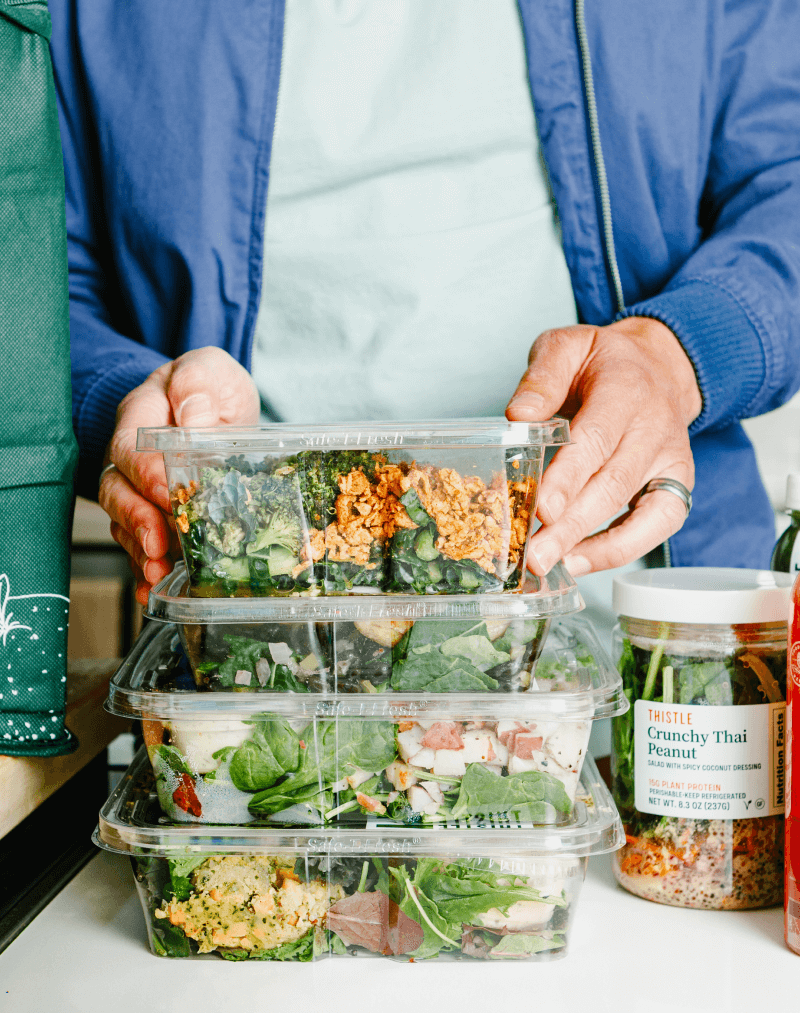 customer arranging a stack of fully prepared Thistle meal boxes